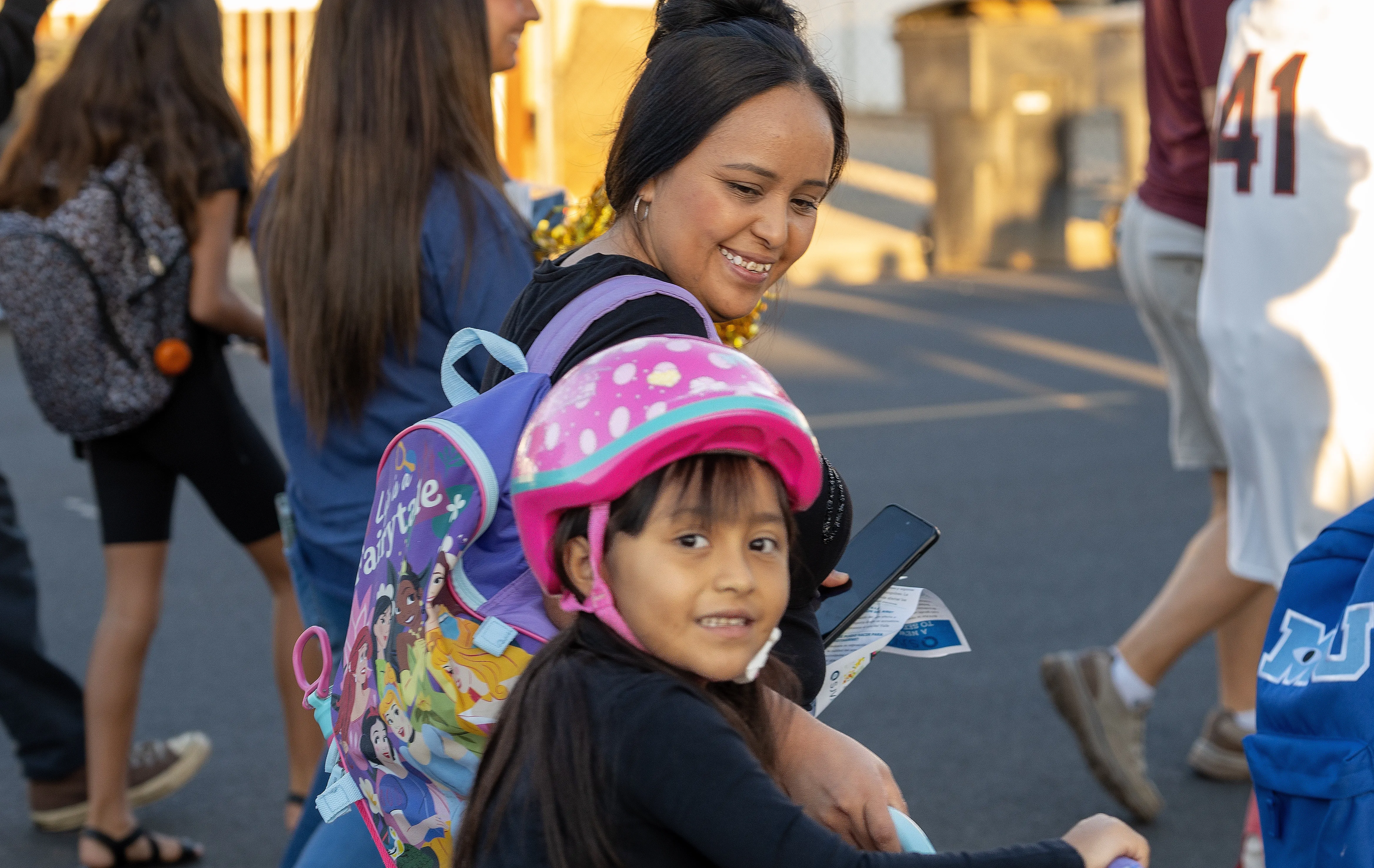 a young girl and her mother on their way to school, smiling all the way