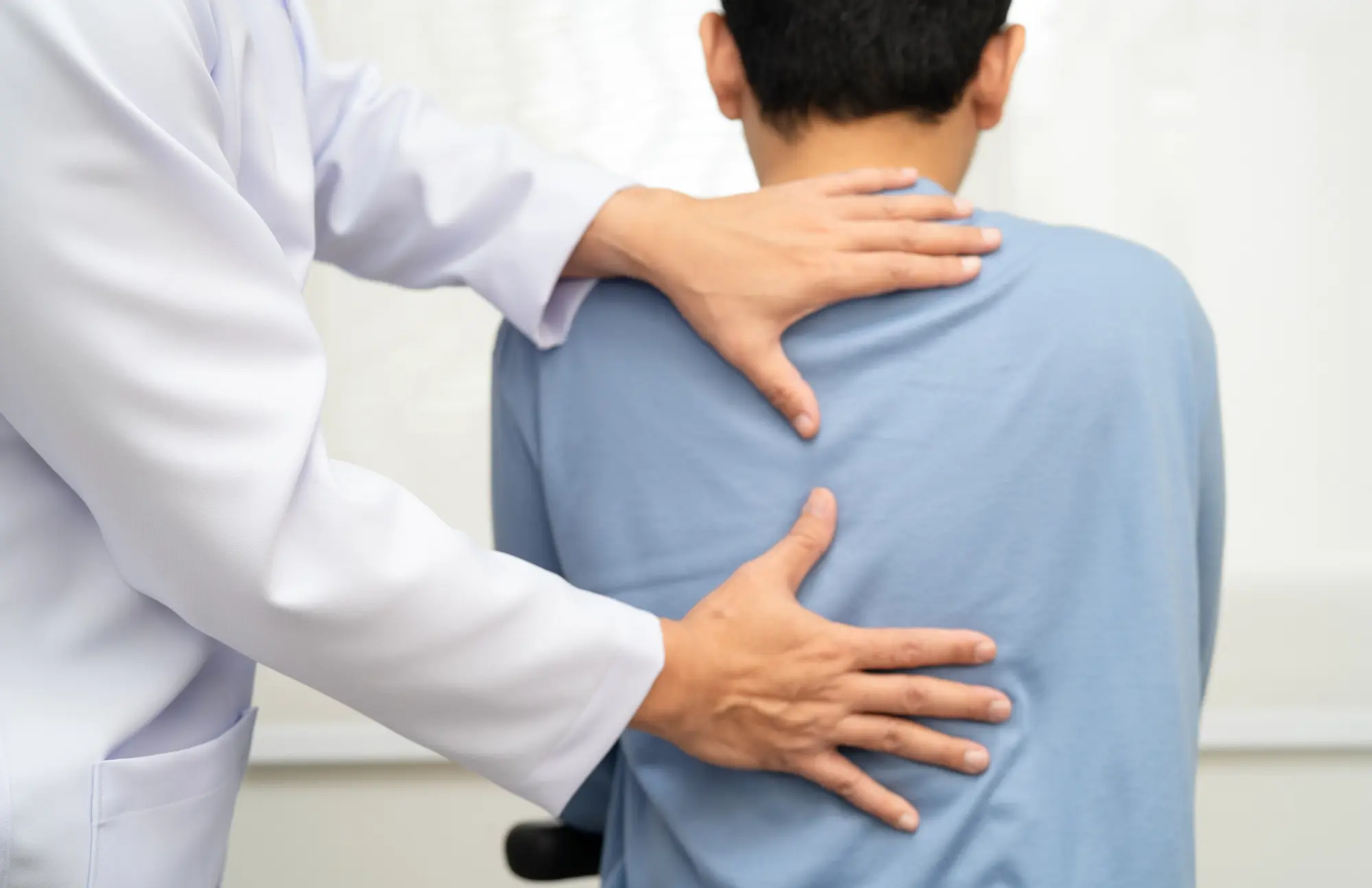 a chiropractor doing an adjustment for a person in a blue shirt